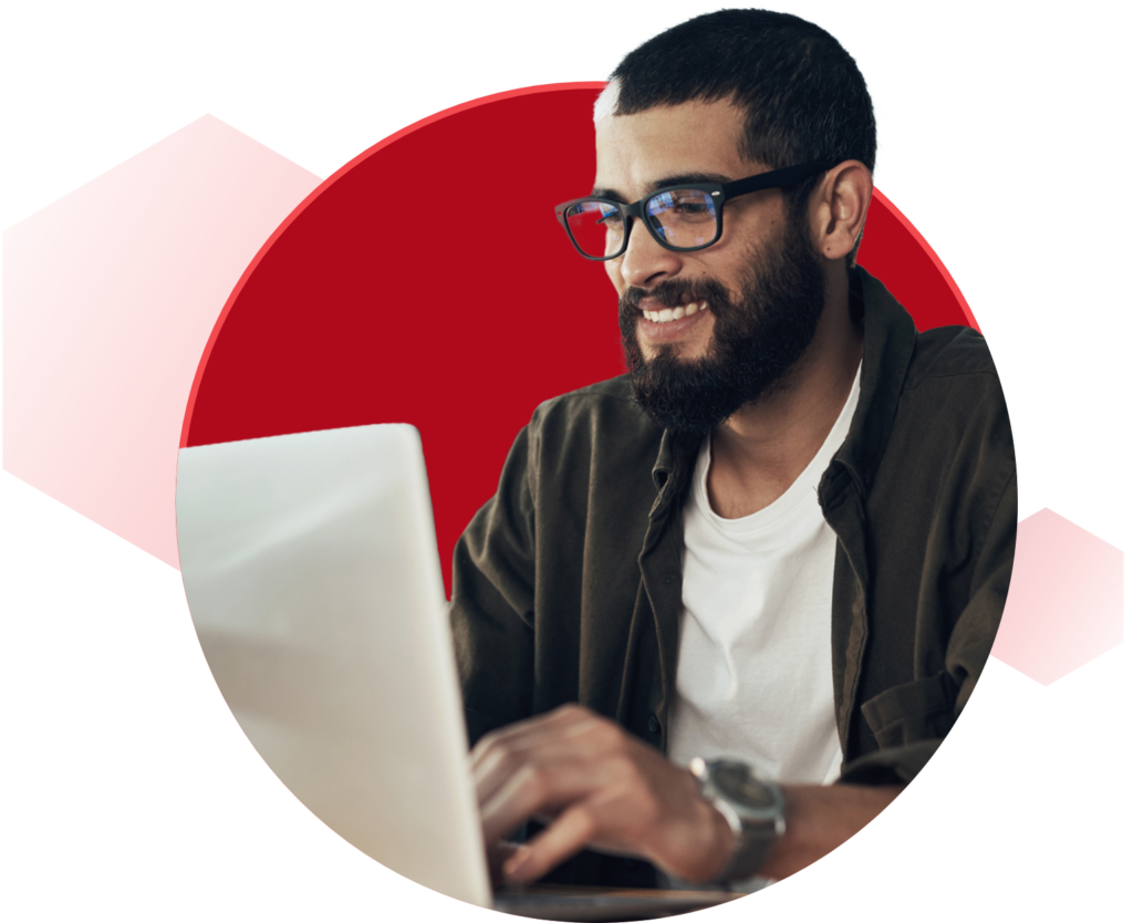 Man smiling while looking at computer in front of hexagon graphic background