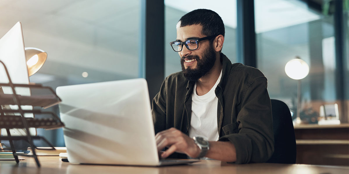 Man smiling while looking at computer